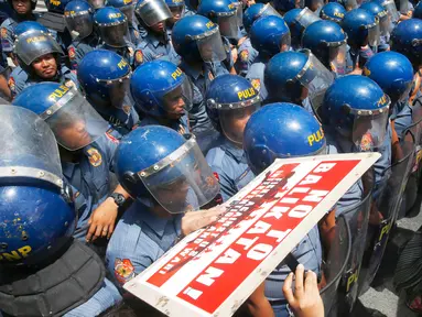 Polisi anti huru hara memblokir sejumlah demonstran yang berusaha mendekat ke Kedutaan Besar AS di Manila, Filipina (17/5). Mereka melakukan aksinya untuk memprotes latihan militer Filipina-AS yang sedang berlangsung.  (AP Photo/Bullit Marquez)
