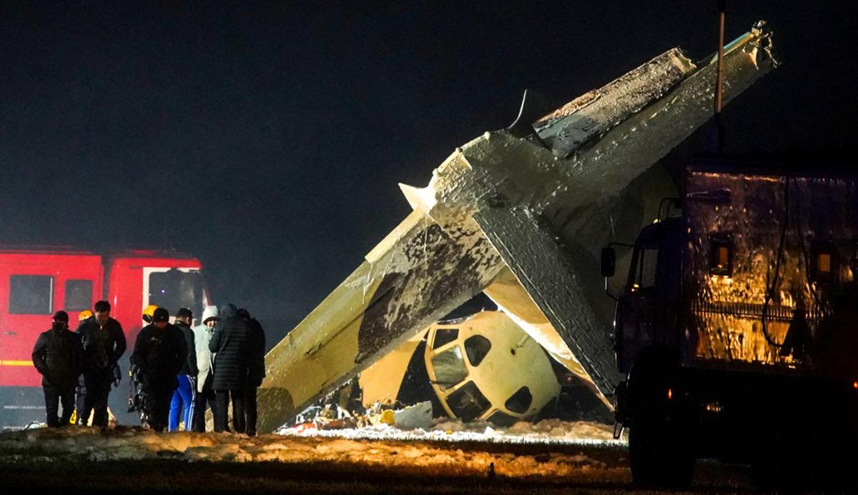 Penyelidik bekerja di lokasi jatuhnya pesawat Antonov An-26 di Bandara Almaty, Kazakhstan, Sabtu (13/3/2021). Pesawat yang terbang dari ibu kota Kazakhstan, Nursultan, tersebut jatuh saat mendarat di Bandara Almaty. (Abduaziz MADYAROV/AFP)
