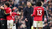 Pelatih kepala Manchester United, Michael Carrick, di tengah, menyapa Patrick Dorgu dari Manchester United setelah pertandingan Liga Inggris antara Manchester United dan Manchester City di Manchester, Inggris, Sabtu, 17 Januari 2026. (AP Photo/Dave Thompson)