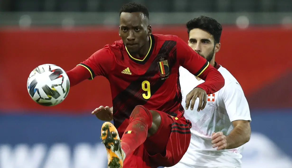 Penyerang Belgia, Dodi Lukebakio berebut bola dengan bek Swiss, Eray Comert dalam pertandingan persahabatan di King Power Stadion At Den Dreef, Kamis (12/11/2020) dini hari WIB. Timnas Belgia Belgia mengalahkan Swiss dengan skor 2-1. (AP Photo/Francisco Seco)