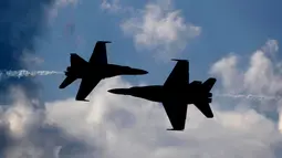 Dua pesawat Blue Angels dari Angkatan Laut AS saling berpapasan dengan kecematan tinggi saat melakukan aksinya di Brunswick, Maine (26/8). (AP Photo / Robert F. Bukaty)