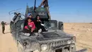 Warga duduk dibagian depan mobil saat melarikan diri setelah terjadinya pertempuran antara pasukan Irak dan militas ISIS di kota Hit, provinsi Anbar, (5/4/2016). (REUTERS/Stringer)