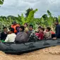 Beberapa penduduk desa terpaksa menggunakan rakit darurat menyelamatkan diri serta membawa harta benda yang masih bisa dibawa. (Sai Aung MAIN/AFP)