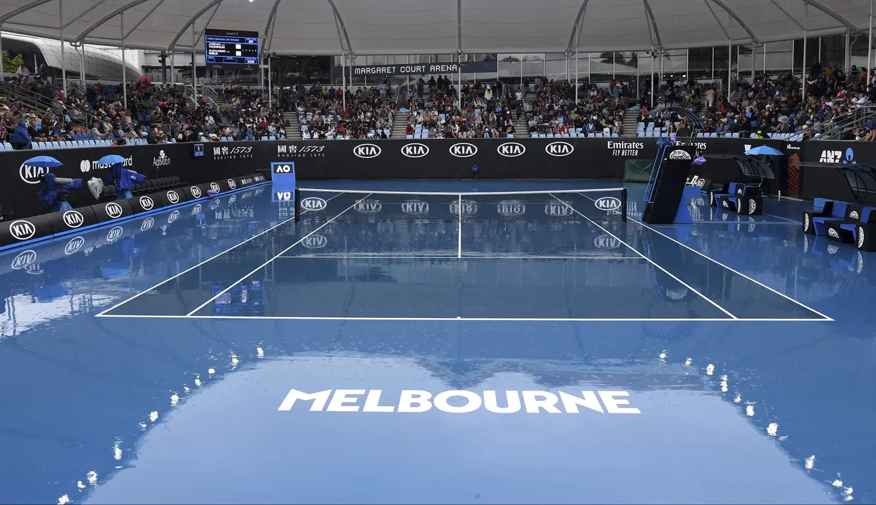 Kondisi lapangan tenis tempat berlangsungnya turnamen Australia Terbuka di Melbourne, Australia, Senin (20/1/2020). Pertandingan Roger Federer melawan Steve Johnson sempat terhenti akibat hujan deras yang mengguyur Rod Laver Arena. (AP Photo/Andy Brownbill)