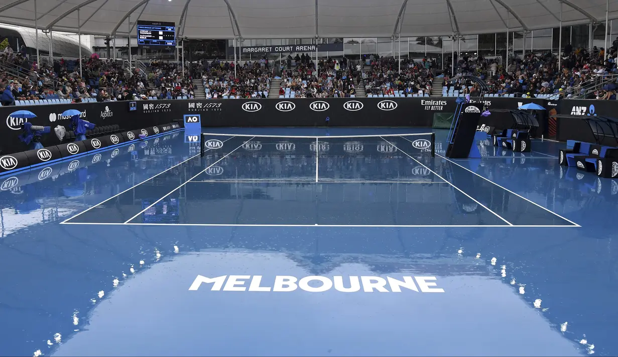 Kondisi lapangan tenis tempat berlangsungnya turnamen Australia Terbuka di Melbourne, Australia, Senin (20/1/2020). Pertandingan Roger Federer melawan Steve Johnson sempat terhenti akibat hujan deras yang mengguyur Rod Laver Arena. (AP Photo/Andy Brownbill)