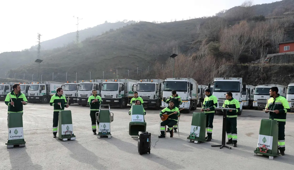 Anggota "Grup Tin" yang bekerja sebagai petugas kebersihan kota memperlihatkan keahlianya bermain musik dengan menggunakan tempat sampah dan barang bekas di distrik Cankaya, Ankara, Turki (9/1). (AFP Photo/Adem Altan)