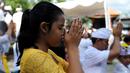 Umat Hindu berdoa saat perayaan Kuningan di sebuah pura di Pulau Serangan, Denpasar, Bali, Sabtu (20/2). Kuningan merupakan hari terakhir perayaan Galungan diyakini menjadi hari kekuasaan roh suci leluhur kembali ke langit. (AFP PHOTO/SONNY Tumbelaka)
