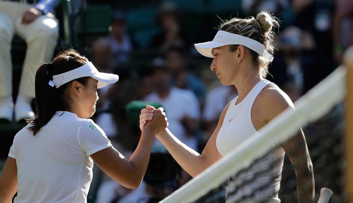 Petenis asal Jepang, Kurumi Nara bersalaman dengan Kurumi Nara dari Jepang usai pertandingan pada hari kedua tunggal putri Kejuaraan Tenis Wimbledon di London, (3/7).  Dalam pertandingan ini Kurumi Nara takluk dari Simona Halep. (AP Photo / Ben Curtis)