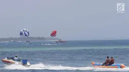 Turis menikmati permainan Parasailing di pantai Nusa Dua Bali, Rabu (10/10). Penyelenggaraan IMF - Bank Dunia Bali 2018 diharapkan dapat memberi imbas lebih baik di Indonesia khususnya sektor pariwisata. (Liputan6.com/Angga Yuniar)