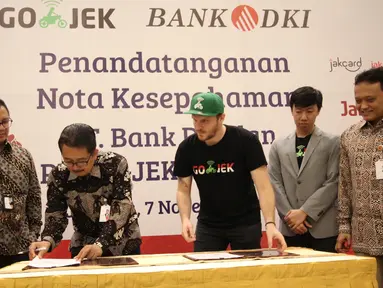 Direktur Bisnis Bank DKI,  Antonius Widodo Mulyono (kedua kiri) dan CMO Go-Jek,  Piotr Jakubowski (tengah) saat MoU antara Bank DKI dengan Gojek Indonesia, Selasa (7/11). (Liputan6.com/Pool/Budi)