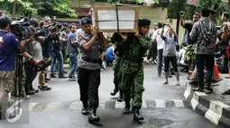 Petugas mengangkat 13 peti ke ruang transit jenazah yang dipersiapkan untuk korban helikopter TNI yang jatuh di RS Polri, Jakarta, Senin (21/3). Kecelakaan yang diduga akibat petir ini, menyebabkan 13 orang meninggal dunia. (Liputan6.com/Yoppy Renato)