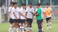 Bima Sakti (hijau) memberikan instruksi kepada para pemain Timnas Indonesia U-17 dalam sesi latihan di Lapangan ABC, Kompleks Gelora Bung Karno, Jakarta, Kamis (27/7/2023) pagi. (Bola.com/Abdul Aziz)