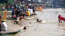 Seorang pemuda melompat dari kapal untuk menangkap bebek yang dilempar ke kali Cisadane pada perayaan Peh Cun di Pasar Lama, Kota Tangerang, Kamis (9/6). Sebanyak 100 bebek dilepas sebagai tradisi ungkapan buang kias. (Liputan6.com/Fery Pradolo)