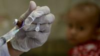 Seorang petugas kesehatan bersiap untuk memberikan vaksin polio kepada balita di sebuah posyandu di Banda Aceh, Aceh, Rabu (4/10/2020). Pemberian vaksin polio dan vaksin campak secara gratis yang berlanjut di tengah pandemi COVID-19 bertujuan memperkuat imunitas anak. (CHAIDEER MAHYUDDIN / AFP)