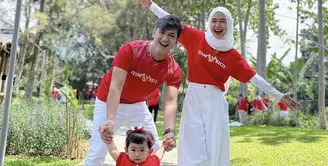 Ria Ricis bersama suami dan anaknya kompak mengenakan baju atasan merah dengan bawahan putihnya. [@riaricis1795]