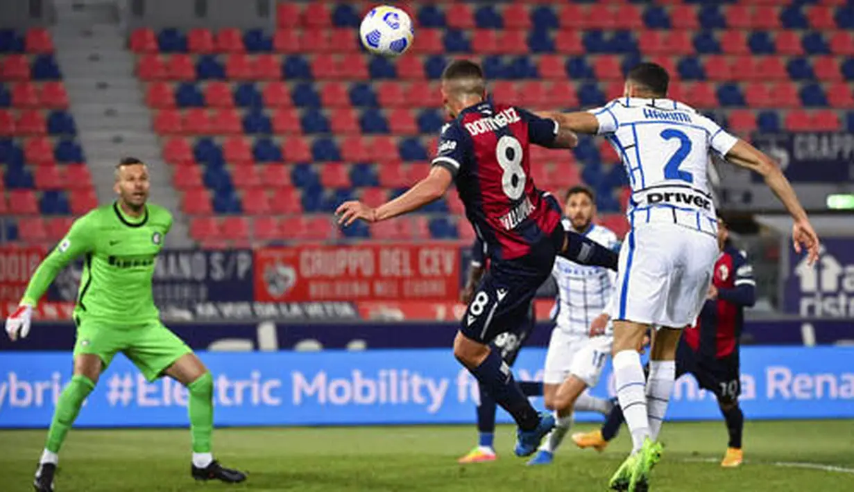 Bek Inter Milan, Achraf Hakimi, duel udara dengan pemain Bologna, Nicolas Dominguez, pada laga Serie A di Stadion Renato Dall'Ara, Sabtu (3/4/2021). Inter Milan menang dengan skor 1-0. (Massimo Paolone/LaPresse via AP)