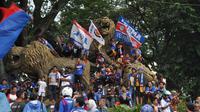 Aremania memadati patung Singa saat menyambut tim Arema Cronus dalam pawai juara Torabika Bhayangkara Cup 2016, Selasa (5/4/2016). (Bola.com/Iwan Setiawan) 