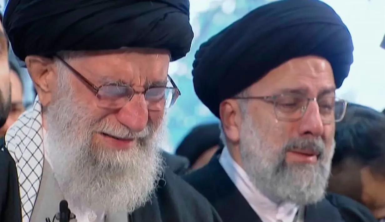 Pemimpin Tertinggi Iran, Ayatollah Ali Khamenei menangis saat berdoa atas jenazah Mayor Jenderal Qassem Soleimani di Universitas Teheran, Senin (6/1/2020). Qassem Soleimani tewas setelah menjadi target serangan drone AS di Bandara Internasional Baghdad beberapa hari lalu. (Iran Press TV via AP)