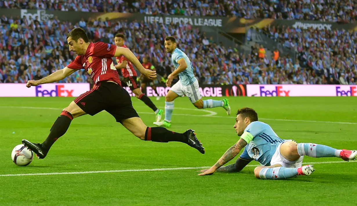 Gelandang Manchester United, Henrikh Mkhitaryan (kiri) mengiring bola meletawati bek Celta Vigo, Hugo Mallo pada pertandingan leg pertama semifinal Liga Europa di stadion Balaidos, Spanyol (5/5). MU menang 1-0 atas Celta Vigo. (AFP Photo/Miguel Riopa)