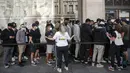 Karyawan Nike meminta orang-orang yang antre untuk menjaga jarak di luar toko Niketown di London, Senin (15/6/2020). Antrean panjang terjadi di luar toko-toko yang berada di sejumlah kota di Inggris saat negara itu melakukan pelonggaran lockdown dan mulai membuka pusat perbelanjaan. (AP/Matt Dunham)
