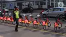 Petugas keamanan melintas di dekat deretan sepeda untuk layanan bike sharing atau penyewaan sepeda di Kawasan Jakarta, Jumat (3/7/2020). Layanan bike sharing yang bertujuan untuk mengurangi penggunaan kendaraan bermotor ini terbagi dalam 6 titik lokasi di Jakarta. (Liputan6.com/Angga Yuniar)