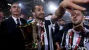 Pemain Juventus Giorgio Chiellini mengangkat trofi Coppa Italia 2017-2018 seusai timnya mengalahkan AC Milan pada pertandingan final di Stadion Olimpico, Kamis (10/5). Juventus sukses meraih gelar ke-13 Coppa Italia. (AP/Gregorio Borgia)