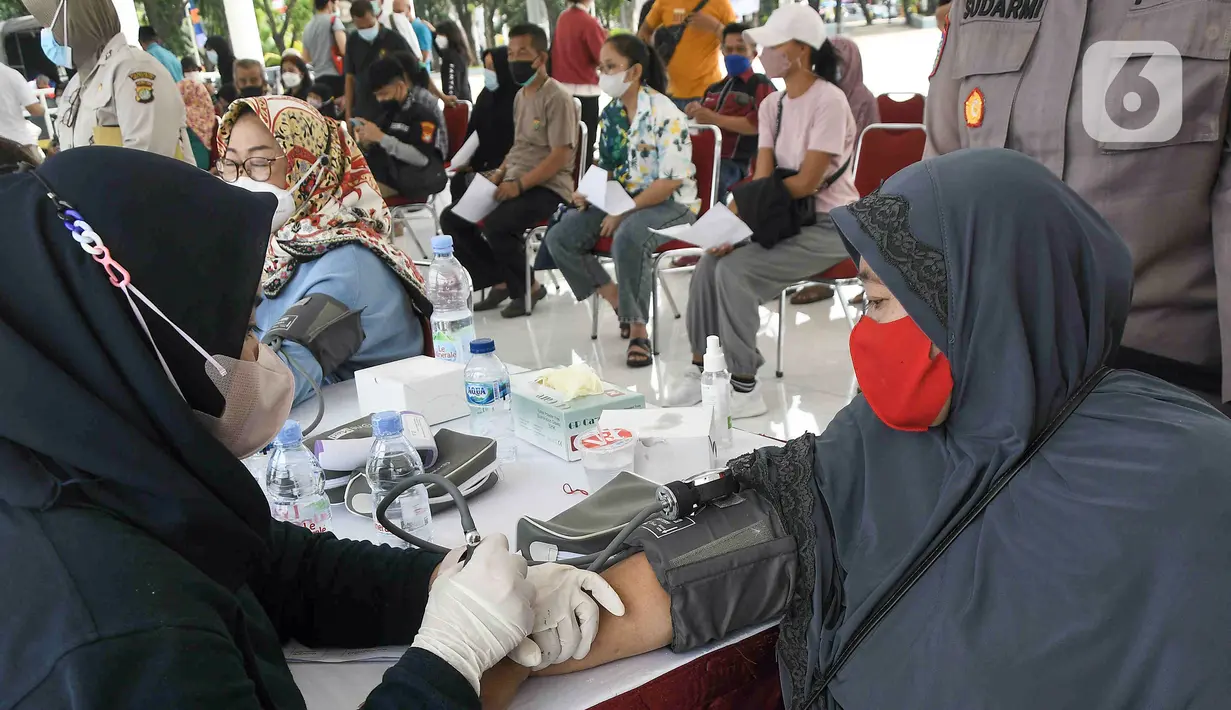 Petugas medis memeriksa kesehatan warga lanjut usia (lansia) sebelum disuntik vaksin Sinovac di Alun-Alun Bekasi, Jawa Barat, Rabu (23/2/2022). Sebanyak 600 dosis vaksin Sinovac disiapkan pemerintah setempat untuk warga lansia guna mencegah penyebaran COVID-19. (Liputan6.com/Herman Zakharia)