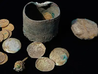 Koin emas kuno dan anting-anting yang ditemukan di sebuah situs penggalian di kota Mediterania Kaisarea, Israel, Senin (3/12). 24 keping koin dan anting-anting emas yang ditemukan dalam sebuah bejana perunggu itu berusia sekitar 900 tahun. (JACK GUEZ/AFP)