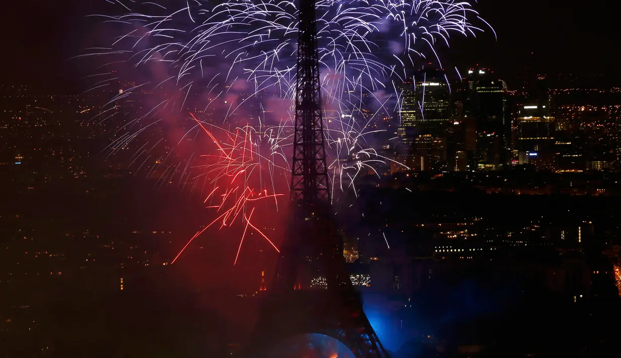 Kembang api mewarnai langit di Menara Eiffel saat perayaan tradisional Hari Bastille di Paris, Prancis (14/7). Peringatan ini menandai penyerbuan penjara Bastille pada 14 Juli 1789, yang memicu revolusi Prancis. (REUTERS/Pascal Rossignol)