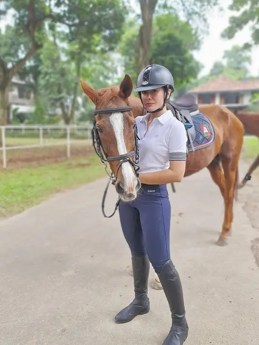 <p>Olahraga lain yang dijalaninya adalah berkuda. Ia tampil memadukan kaos polo dan celana legging serta sepatu boots. (Instagram/wulanguritno).</p>