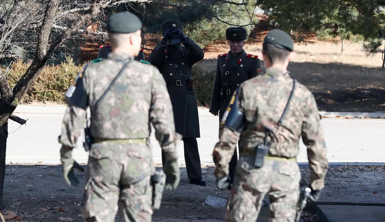 Seorang tentara Korut menggunakan teropong mengawasi kunjungan Menhan Korsel, Song Young-moo di zona Demiliterisasi Panmunjom, Senin (27/11). (AP Photo/Lee Jin-man)