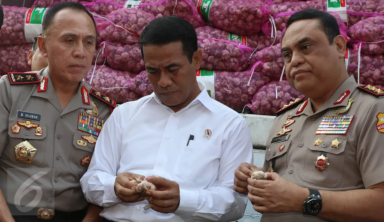 Menteri Pertanian Amran Sulaiman mengecek kualitas bawang putih yang diimpor dari Tiongkok saat operasi pasar di Pasar Induk Kramat Jati, Rabu (17/5). Sebanyak 9.000 ton bawang putih dijual dengan harga Rp 25 ribu per kg. (Liputan6.com/Immanuel Antonius)
