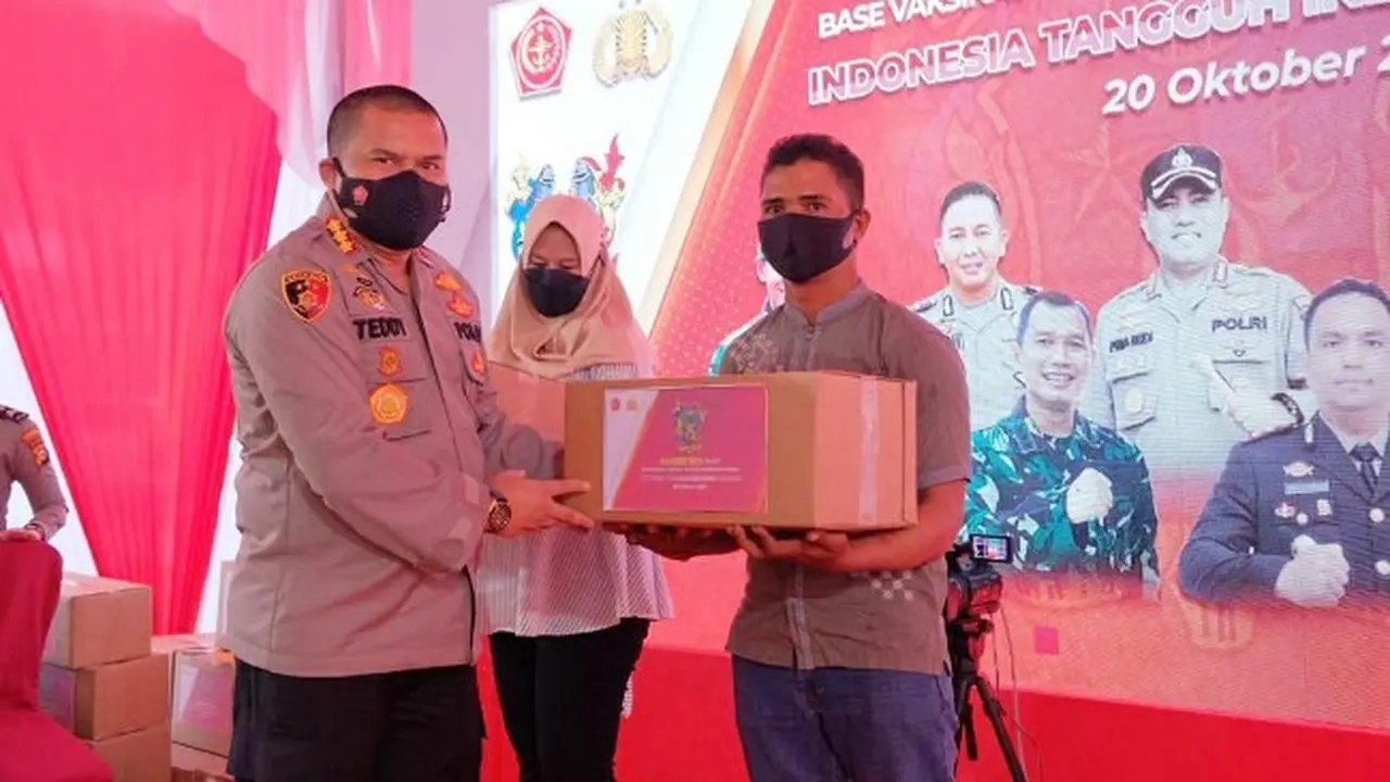Penyerahan bantuan sosial kepada warga terdampak pandemi sekaligus pemberian vaksin Covid-19 oleh alumni Akabri 1999 di Pekanbaru.