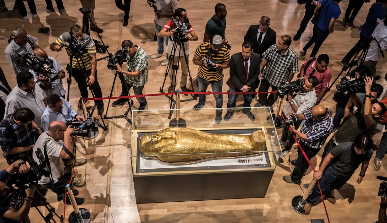 Para jurnalis mengambil gambar peti mati emas mumi Nedjemankh yang dipajang di Museum Nasional Peradaban Mesir, Kairo, Selasa (1/10/2019). Peti mati itu dikembalikan ke Mesir dari AS pekan lalu setelah ditetapkan sebagai barang antik yang dijarah. (Khaled DESOUKI/AFP)