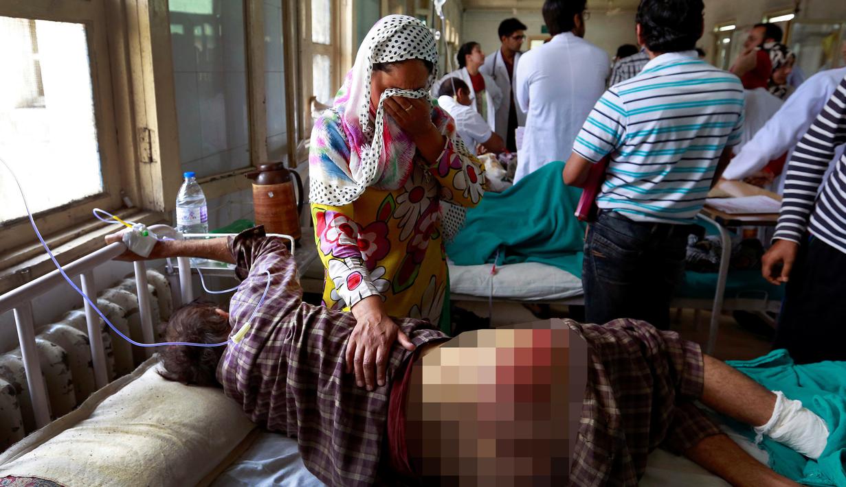 Seorang wanita menangis melihat kondisi salah satu keluarganya yang terluka akibat kerusuhan di Srinagar, Kashmir, Kamis (18/8). Sedikitnya lima orang tewas dan 20 lainnya mengalami luka parah akibat bentrok antara warga dan petugas keamanan. (REUTERS)