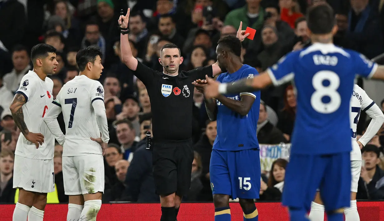Wasit Michael Oliver memberi kartu merah kepada bek Tottenham Hotspur, Cristian Romero (kiri) saat menghadapi Chelsea pada laga lanjutan pekan ke-11 Liga Inggris 2023/2024 di Tottenham Hotspur Stadium, London, Selasa (7/11/2023) dini hari WIB. (AFP/Glyn Kirk)