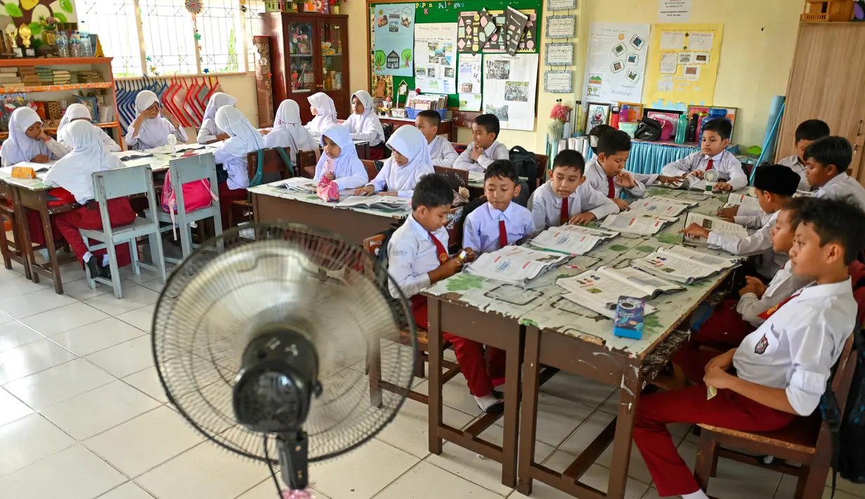 Kipas angin disediakan pihak sekolah untuk siswa sekolah dasar agar tetap sejuk di ruang kelas ditengah cuaca panas.  (AFP/CHAIDEER MAHYUDDIN)
