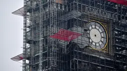 Kondisi jam Big Ben yang tidak ada jarumnya karena sedang dilakukan perbaikan dan pembersihan di London, Inggris (12/4). Jam yang berukuran seberat 13,7 ton ini akan kembali aktif dan berbunyi pada 2021. (AFP Photo/Ben Stansall)