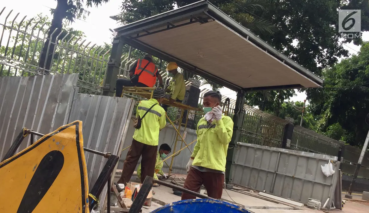 Pekerja menyelesaikan pembuatan halte bus di depan Mesjid Istiqlal, Jakarta, Sabtu (6/1). Pembuatan halte tersebut dilakukan untuk meningkatkan kenyamanan bagi pengguna transportasi umum. (Liputan6.com/Immanuel Antonius)