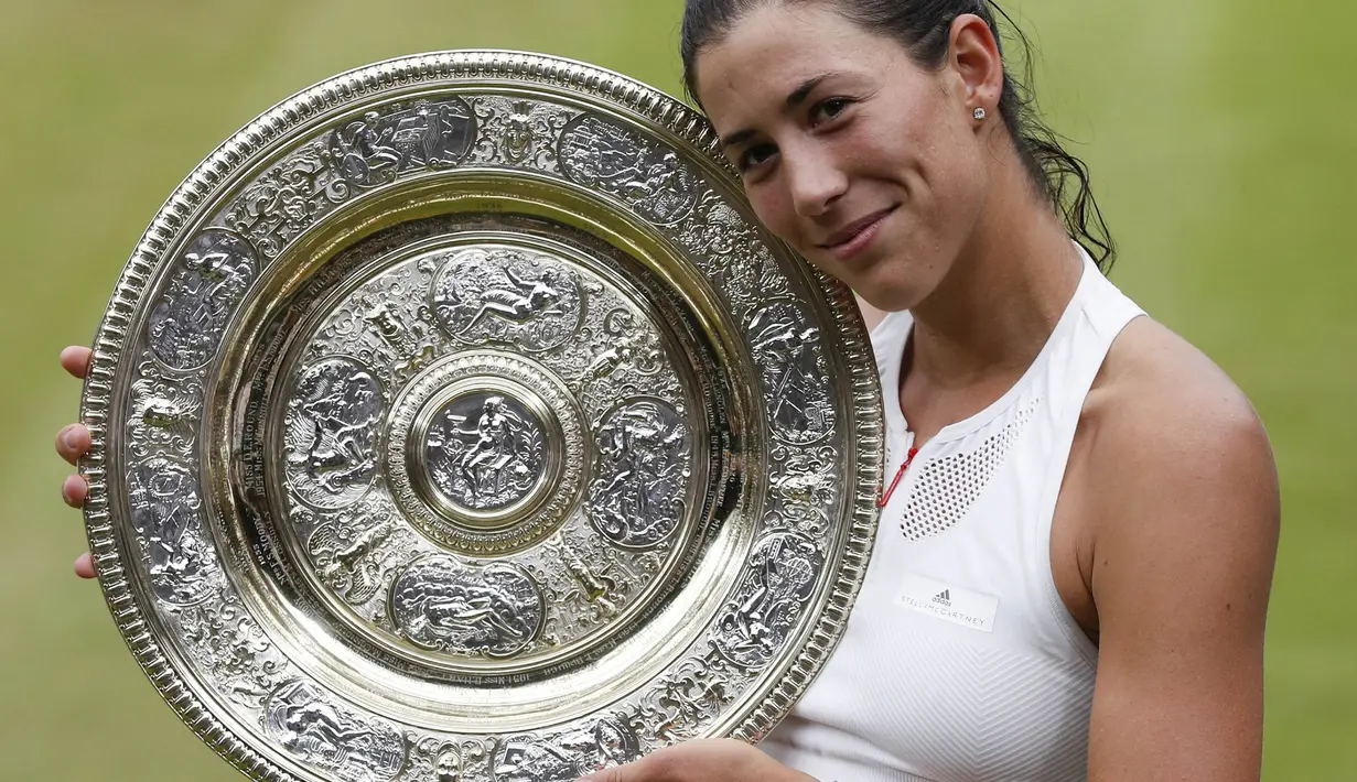 Petenis Spanyol, Garbine Muguruza, merayakan keberhasilannya meraih gelar juara Wimbledon usai menaklukkan Venus Williams di All England Lawn Tennis Club, Inggris, Sabtu (15/7/2017). Muguruza menang 7-5 dan 6-0 atas Williams. (AFP/Adrian Dennis)