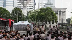 Polisi berjaga menjelang sidang perdana MK Pemilu 2019 di halaman depan Gedung Mahkamah Konstitusi, Jakarta, Jumat, (14/6/2019). Polri kembali menerapkan skema pengamanan empat lapis atau ring untuk mengawal jalannya sidang. (Liputan6.com/Johan Tallo)