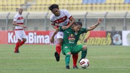 Gelandang PSS Sleman, Kim Jeffrey Kurniawan (kanan) berebut bola dengan bek Madura United, Rendika Rama dalam laga Grup C Piala Menpora 2021 di Stadion Si Jalak Harupat, Bandung, Selasa (23/3/2021). (Bola.com/M Iqbal Ichsan)