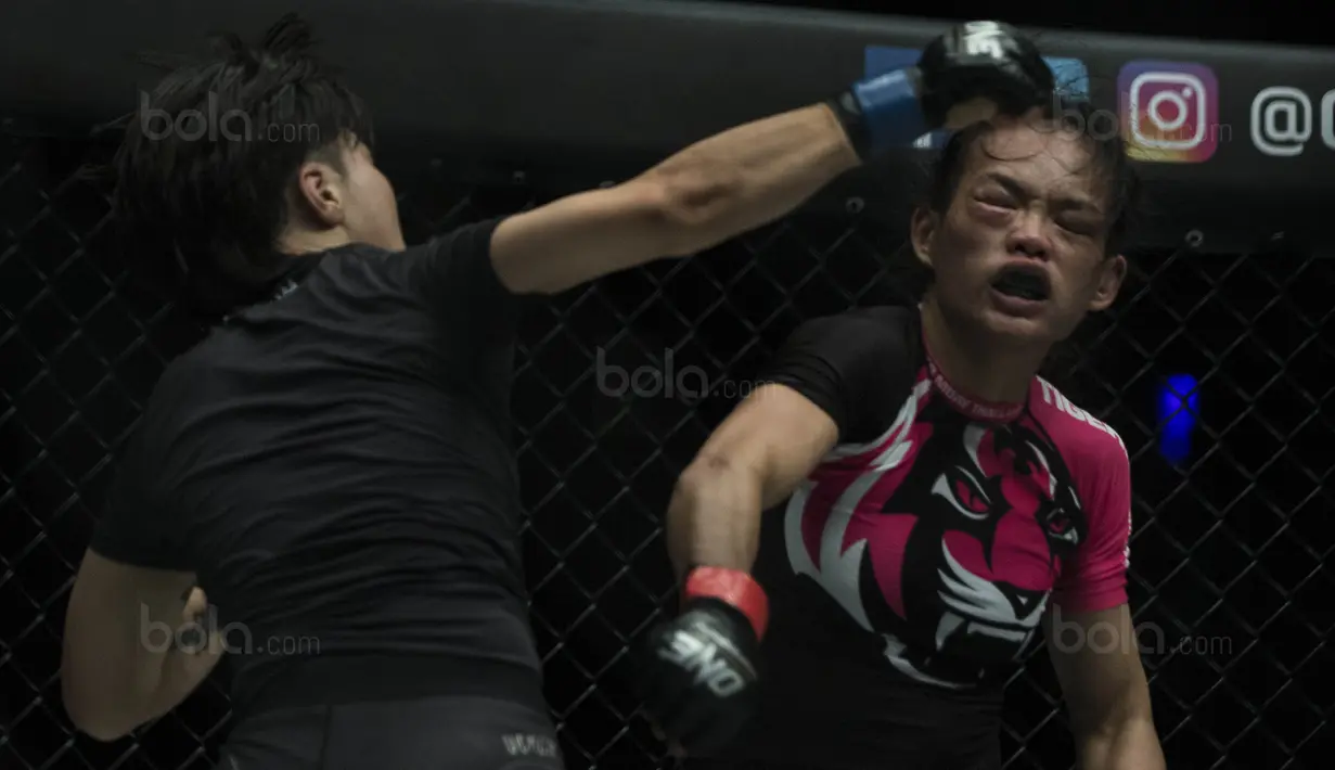 Petarung Cina, Xiong Jing Nan, memukul petarung Singapura, Tiffany Teo, saat laga One Championship di JCC Senayan, Jakarta, Sabtu (20/1/2018). Jing Nan berhasil merebut juara dunia kelas jerami. (Bola.com/Vitalis Yogi Trisna)