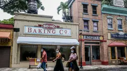 Pengunjung yang mengenakan masker berjalan di taman hiburan Enchanted Kingdom di Provinsi Laguna, Filipina (18/10/2020). Taman hiburan tersebut kembali dibuka untuk pengunjung. (Xinhua/Rouelle Umali)
