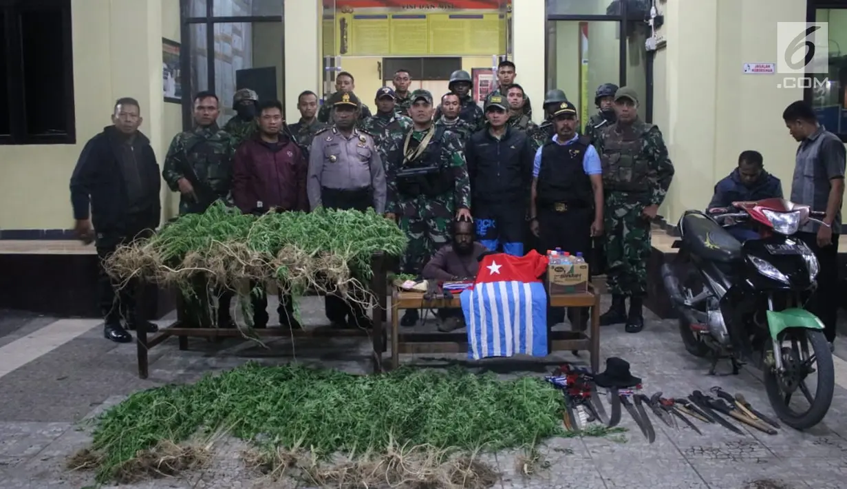 Yonif Raider 756/WMS menyerahkan pelaku pengedar ganja dan barang bukti ke Kapolres Jayawijaya AKBP Yan Reba (3/8). Mereka berhasil mengamankan Sajam, atribut/bendera Bintang Kejora, Miras dan 95, 20 gram ganja kering siap edar. (Liputan6.com/HO/Dispenad)