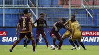Pemain PSM Makassar, Ronaldo Rubener Wanma (tengah) dijaga pemain Bhayangkara Solo FC dalam pertandingan matchday ke-2 Babak Penyisihan Grup B Piala Menpora 2021 di Stadion Kanjuruhan, Malang. Sabtu (27/3/2021). (Bola.com/Ikhwan Yanuar)