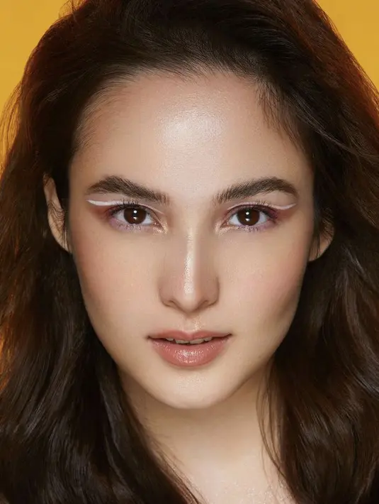 Chelsea Islan tampil chic mengenakan graphic eyeliner warna pink yang dibuat model wings. Ditambah dengan eyeshadow merah di bawaha graphic eyelinernya. Dok instagram @archangelachelsea.