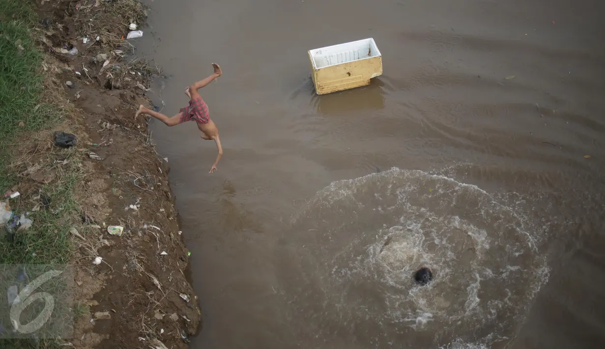 Seorang anak melompat dan berenang di aliran kali besar Banjir Kanal Barat, Jakarta, Sabtu (11/3). Tanpa mempedulikan kesehatan, sejumlah bocah tersebut terlihat asyik berenang di kali yang kondisi airnya keruh. (Liputan6.com/Faizal Fanani)