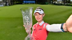 Nelly Korda meniru gaya swafoto berpose dengan trofi usai menjuarai final LPGA Gainbridge di Lake Nona Golf and Country Club, Minggu (28/2/2021). (Foto: AFP/Getty Images/Julio Aguilar)