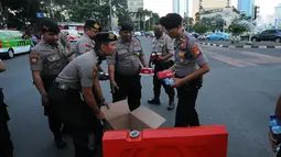 Aparat kepolisian yang melakukan penjagaan mendapatkan makanan berbuka puasa dari relawan TKN Jokowi-Ma'ruf Amin di kawasan Bundaran HI, Jakarta, Jumat (24/5/2019). Kegiatan ini sebagai bentuk kepedulian untuk aparat yang telah menjaga keamanan di Jakarta. (Liputan6.com/Angga Yuniar)